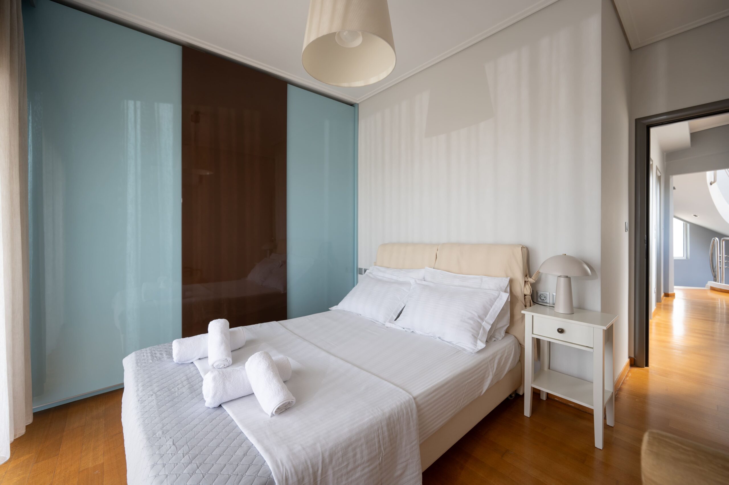 Cozy twin bedroom with soft lighting and wardrobe